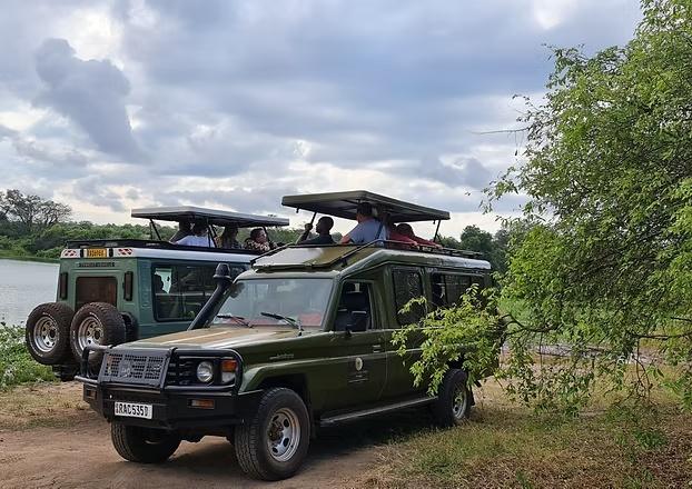 Safari vehicles beside the water