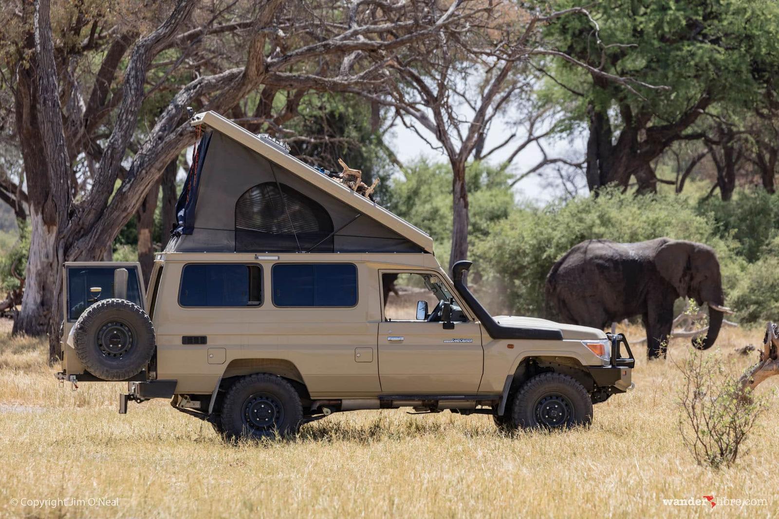 Land Cruiser with roof tent near elephants